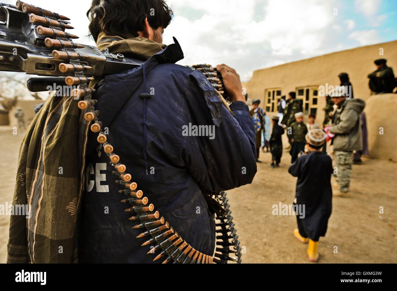 Un nazionale afghano di poliziotto porta una mitragliatrice attraverso un villaggio durante un giunto pattuglia di sicurezza durante la guerra in Afghanistan 30 novembre 2009 nella provincia di Zabul Shabila Kalan, Afghanistan. Foto Stock