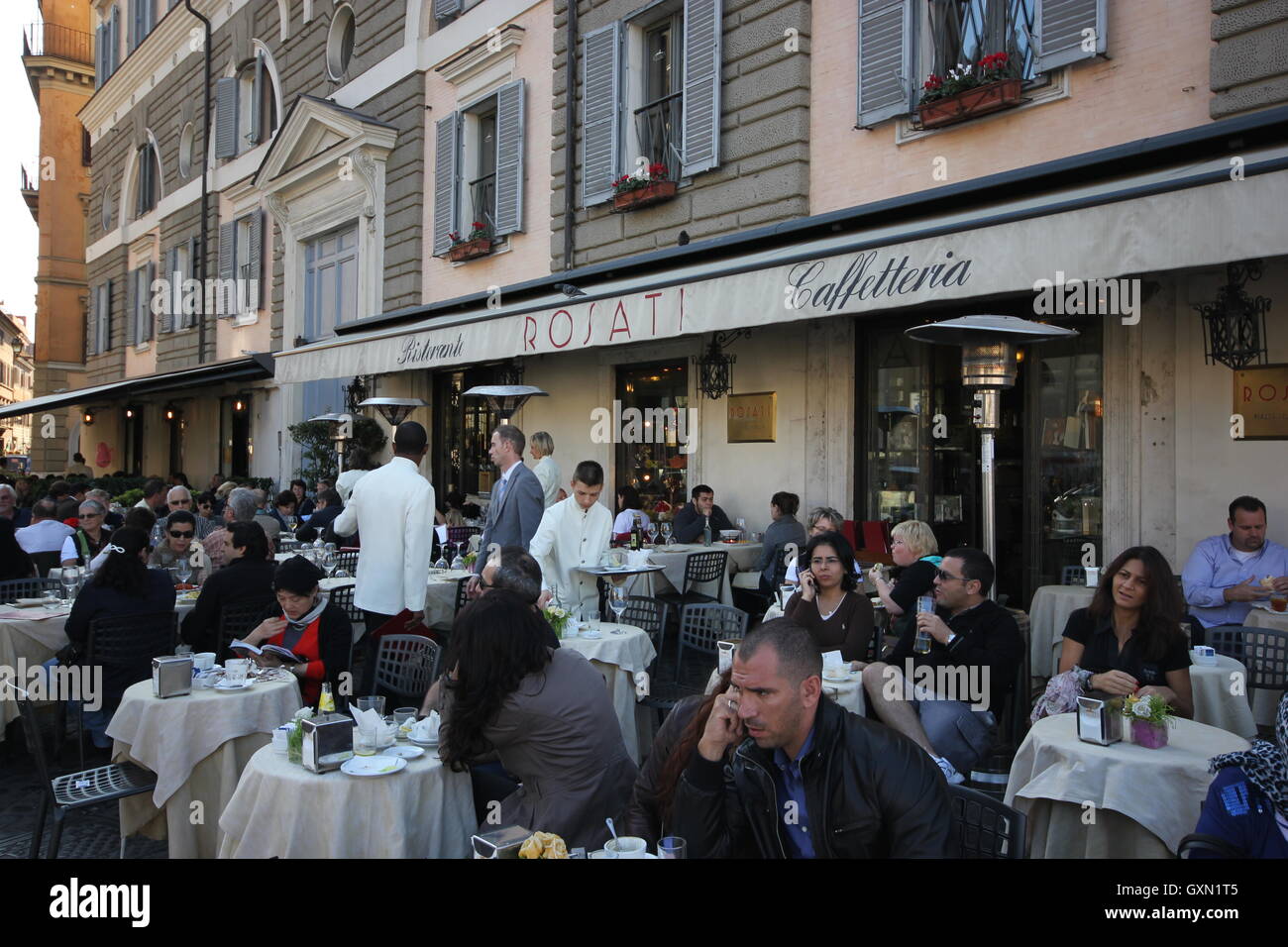 La gente seduta al di fuori di una caffetteria nella famosa Piazza del Popolo, Roma, Italia Foto Stock