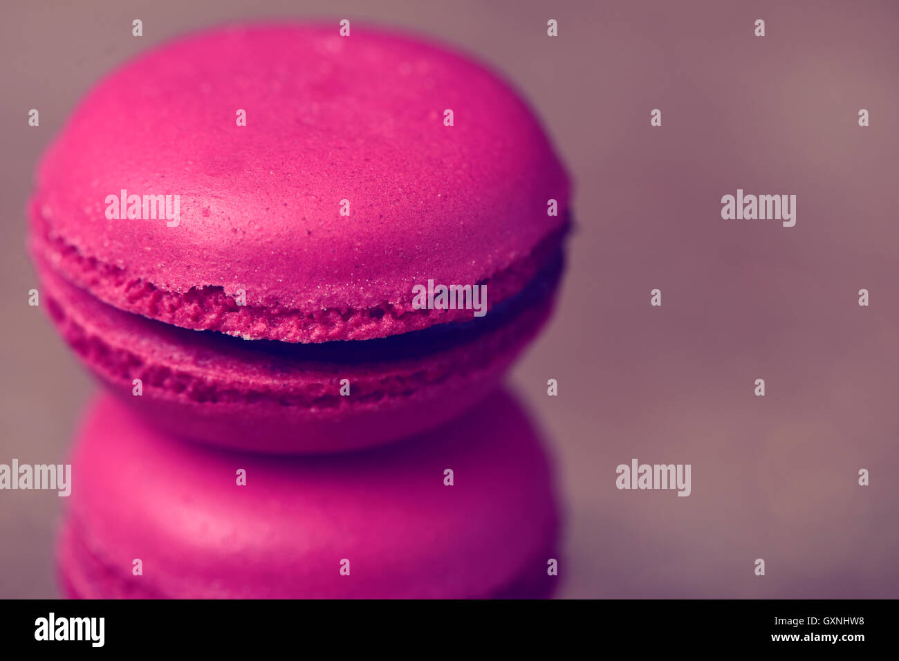 Primo piano di una pila di appetitosi viola macarons contro uno sfondo grigio Foto Stock