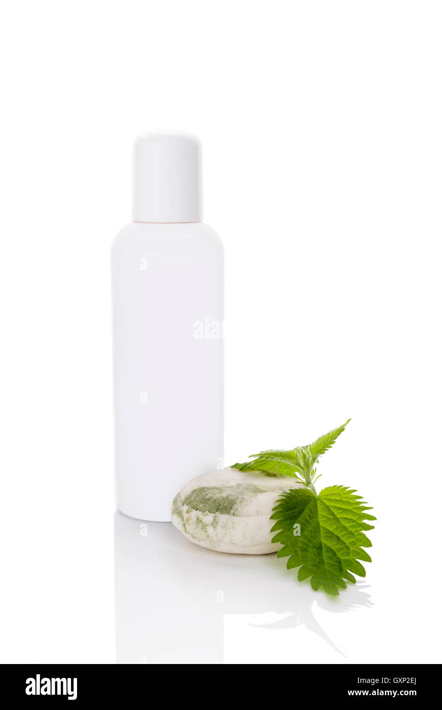 Ortica cosmetici mockup. Fresh Ortica foglie e bottiglia di plastica bianca senza etichetta isolato su bianco Foto Stock