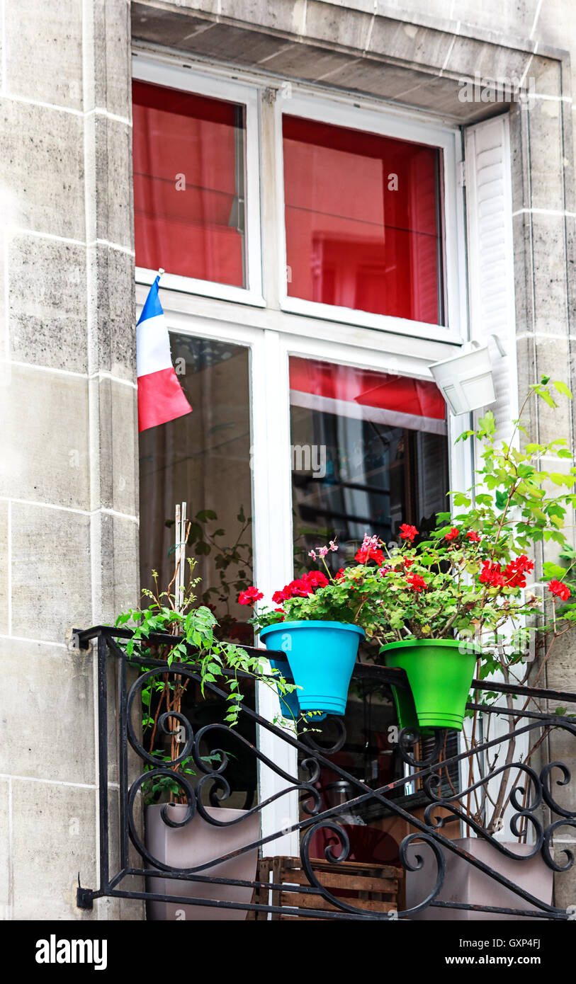 Parigi- Finestra Francese con fiori e flag Foto Stock