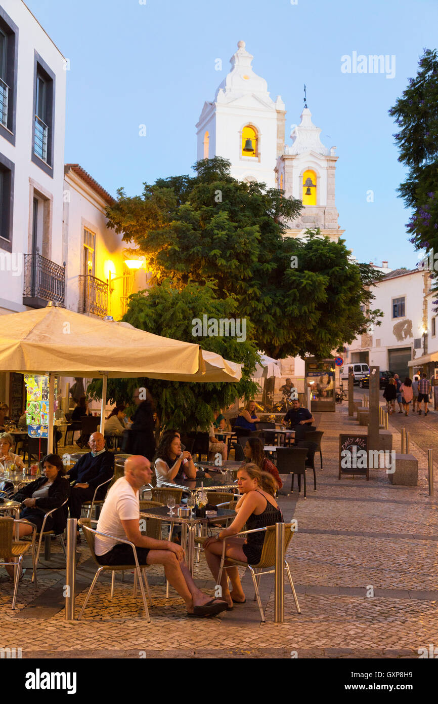 La gente seduta a un cafè all'aperto la sera presto, Lagos città vecchia, Algarve, Portogallo Europa Foto Stock