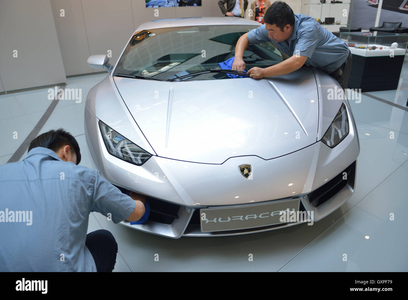 Gli uomini cinesi pulire una Lamborghini a uno showroom in AUDI la Cina a Pechino in Cina. 05-set-2016 Foto Stock
