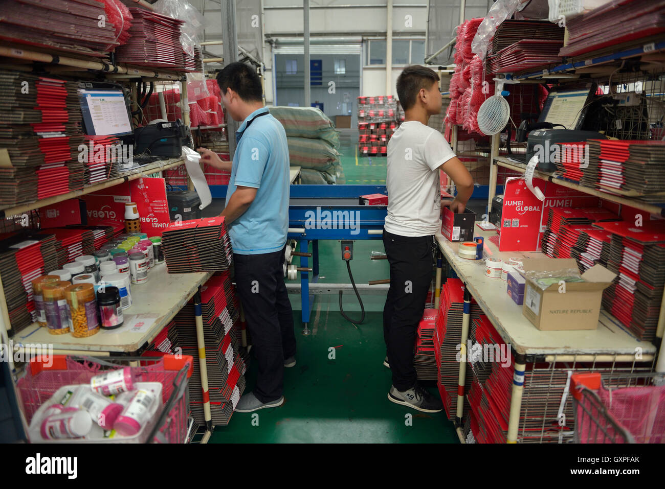 Lavoratori avvolgere pacchi di merci effettuato acquisti da oltremare attraverso Jumei Global online canale durante la consegna al EHL Registro internazionale Foto Stock
