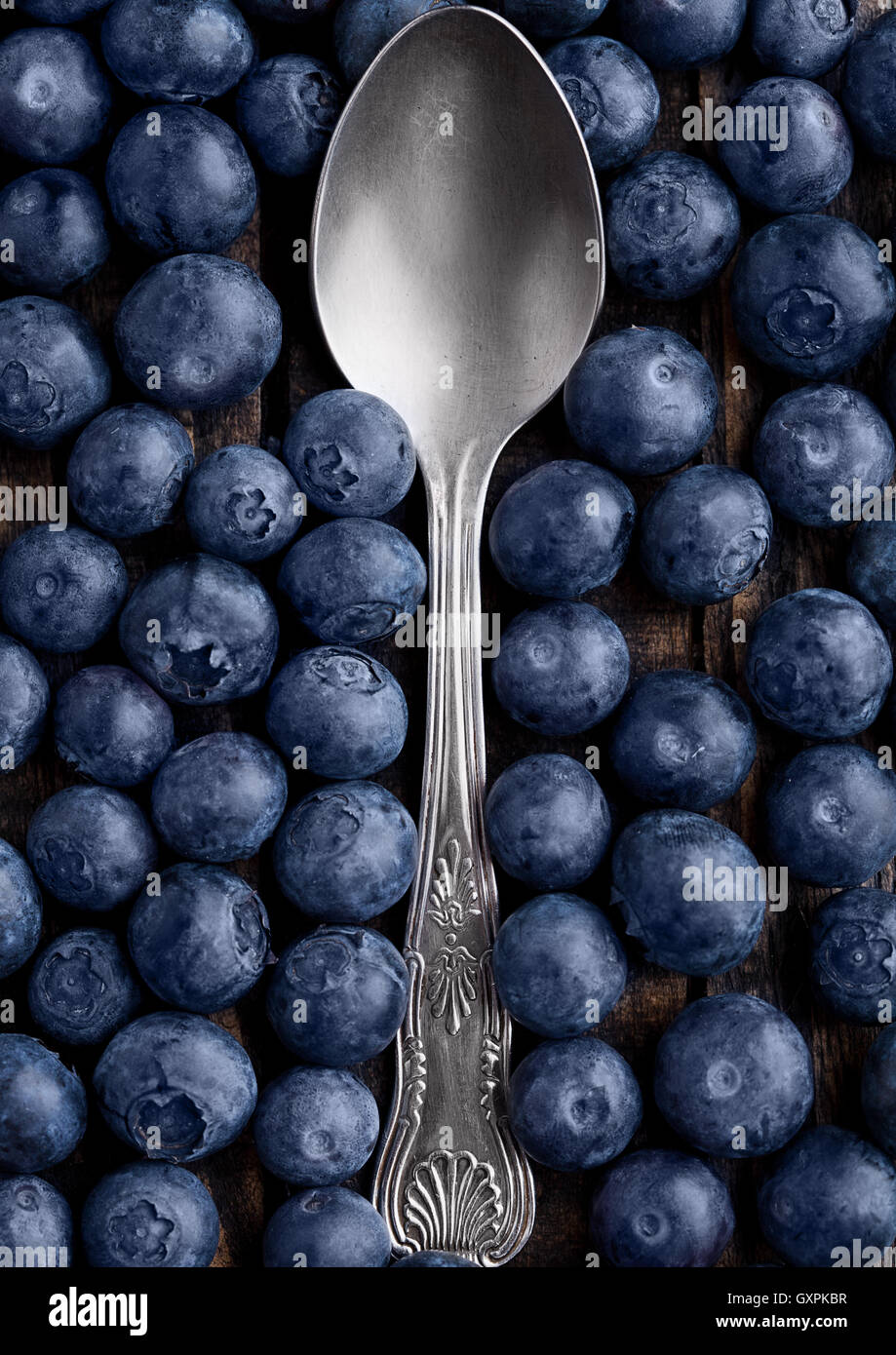 I mirtilli attorno al cucchiaio close up foto. Naturale cibo sano. Still Life fotografia Foto Stock