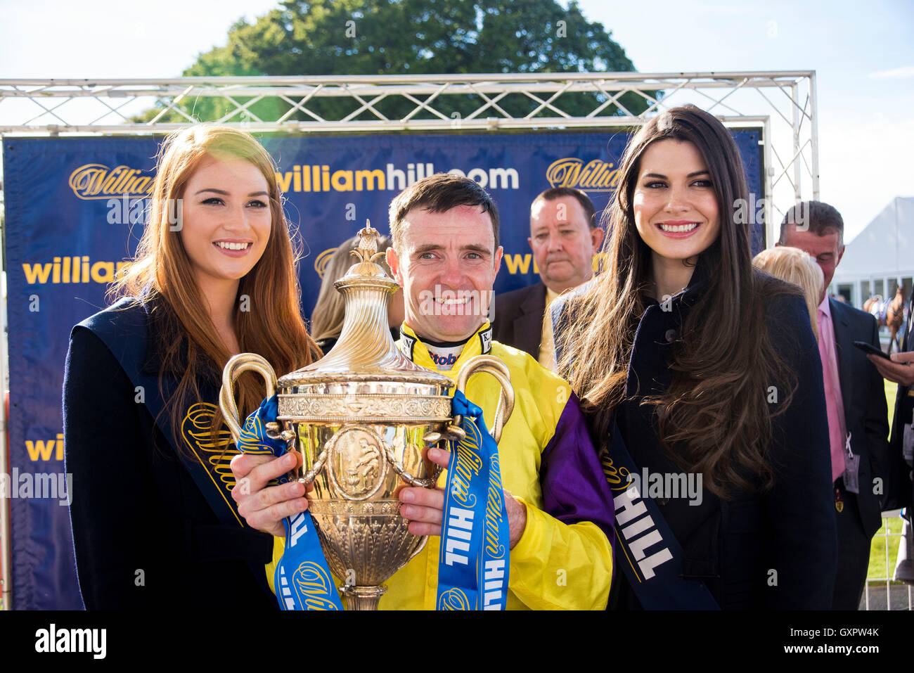 Jockey Tom Eaves festeggia conquistando la William Hill Ayr Gold Cup su Brando, presentato da Miss Scozia Lucy Kerr e Mhairi Fergusson durante il giorno tre del 2016 William Hill Ayr Gold Cup Festival a Ayr Racecourse. Foto Stock