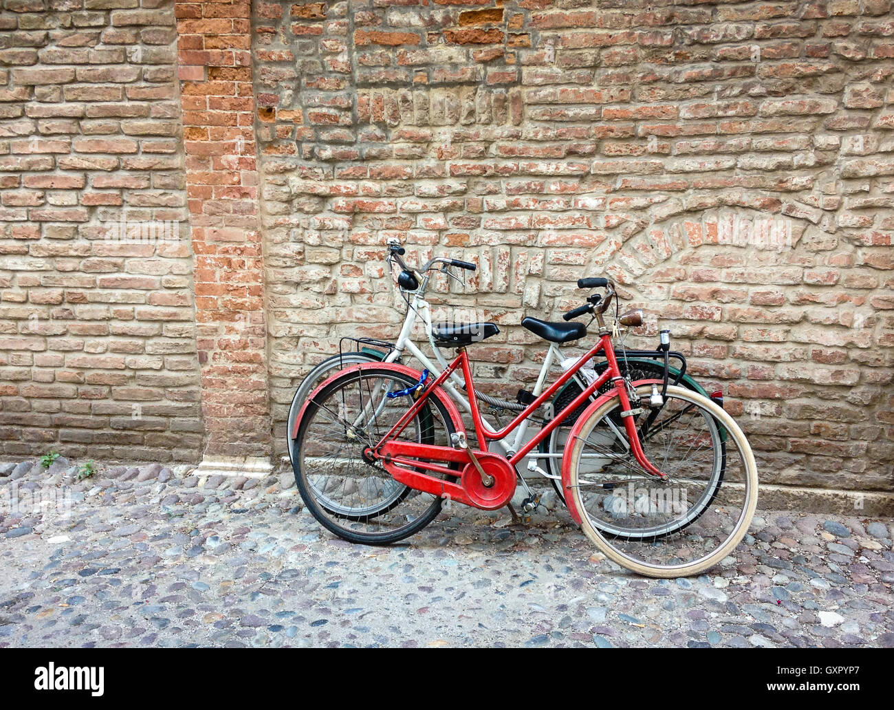 Due moto vicino all'antico muro di mattoni in Italia Foto Stock