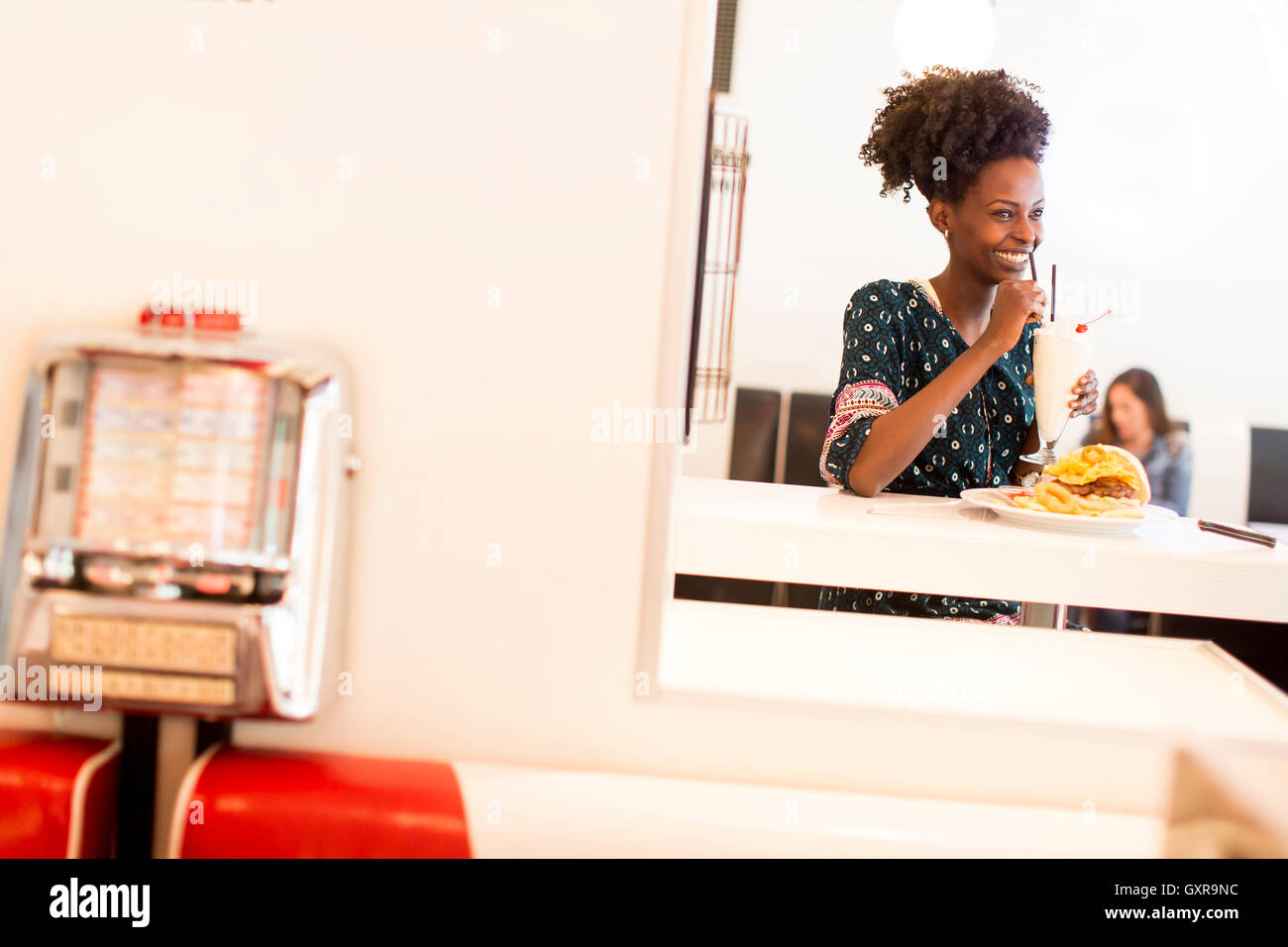 Giovane africano donna americana nel diner Foto Stock