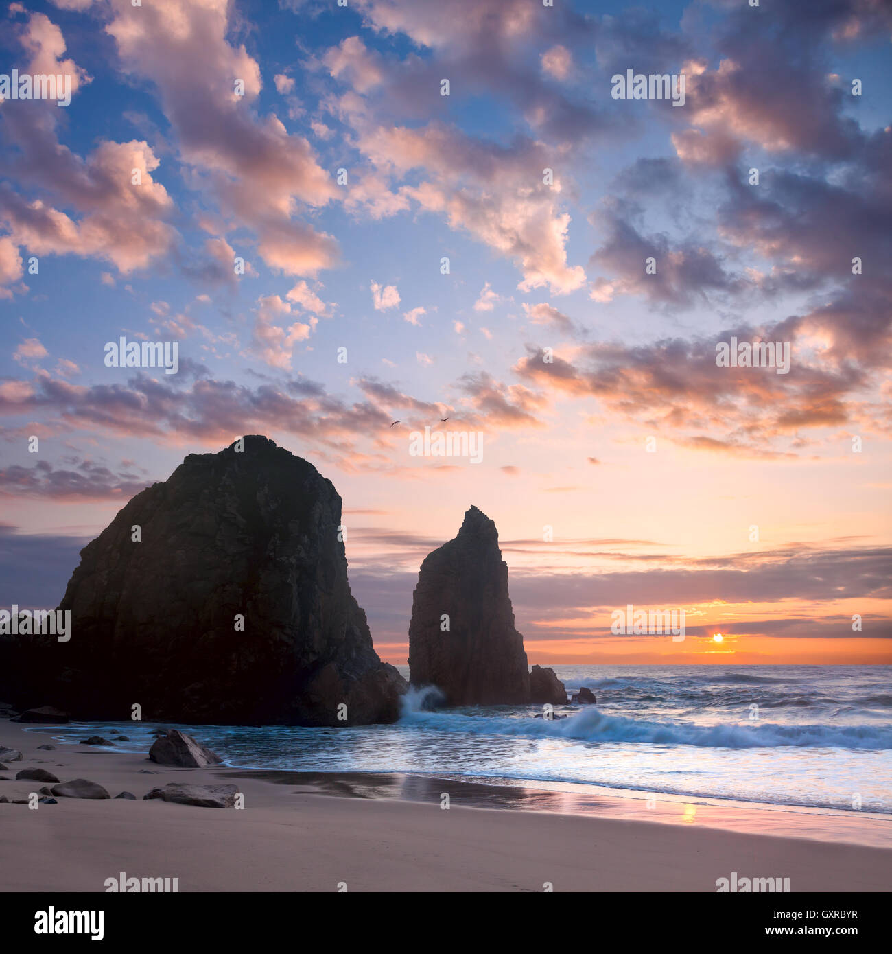 Paesaggio dell'oceano al tramonto romantico, tempo di grandi rocce e spiaggia di pietre. Il Portogallo, Europa Foto Stock