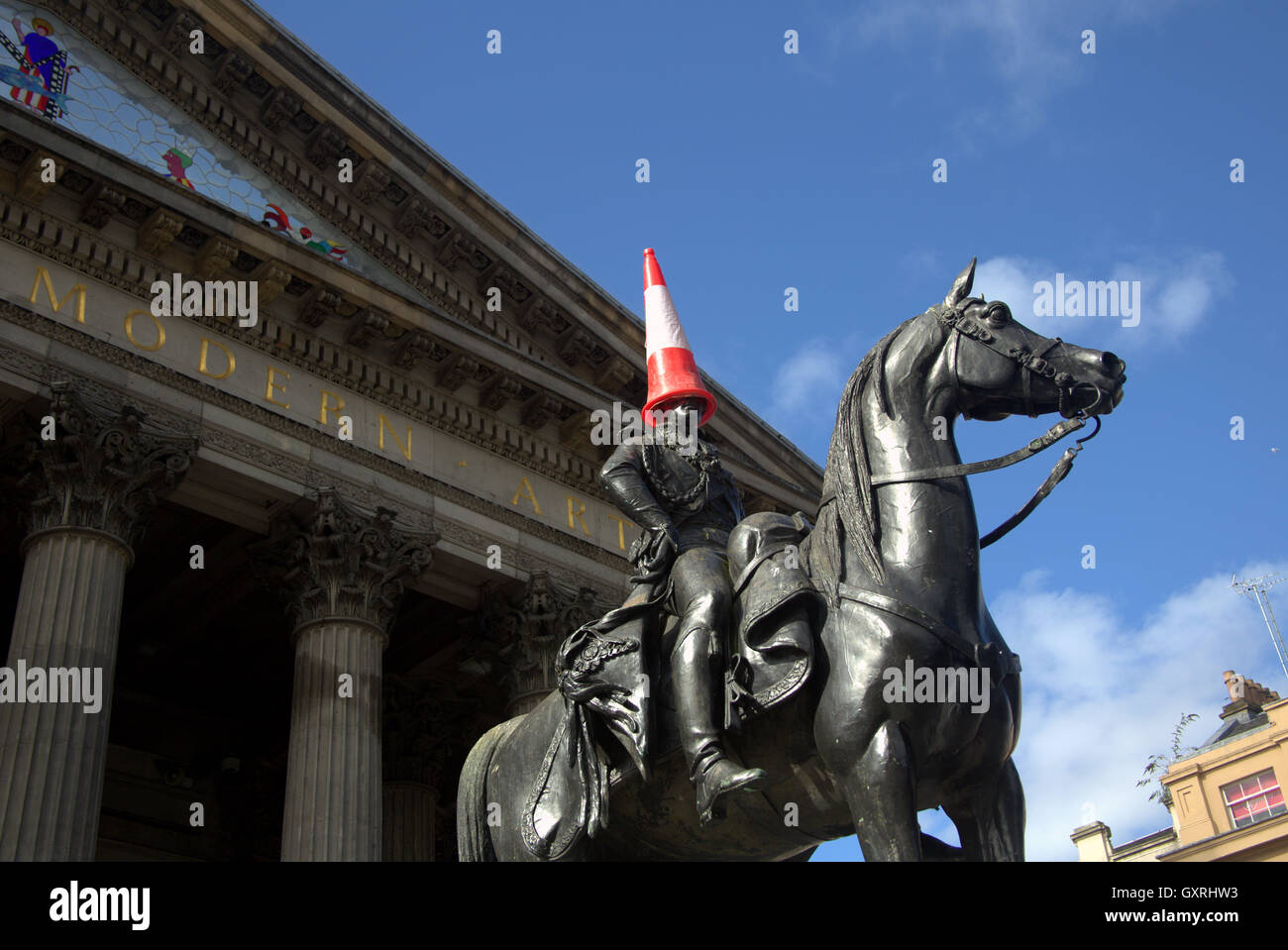 Glasgow il Museo di Arte Moderna di tipo iconico testa conica si crogiola al sole, il Duca di Wellington statua appropriatamente adattato dal consenso locale Foto Stock