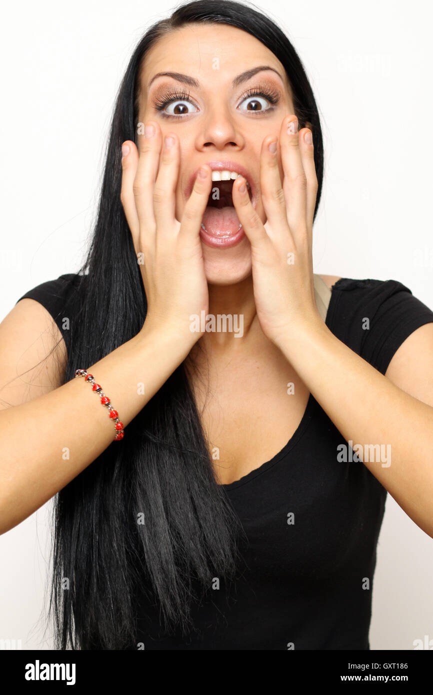 Giovane donna con espressione strano isolato su bianco Foto Stock