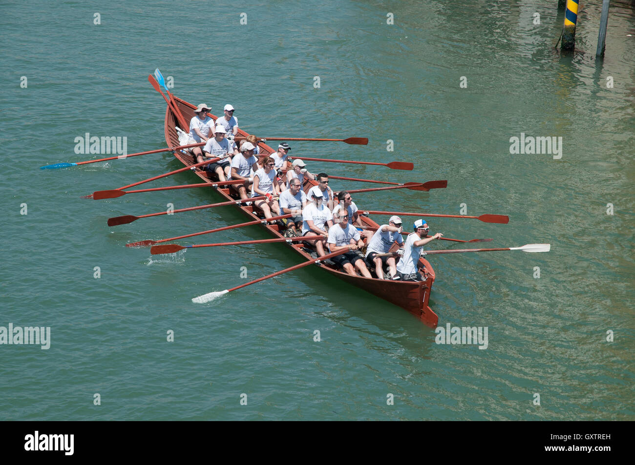 Barca a remi lungo il Canal Grande a Venezia per il Volga lunga dal ponte dell'Accademia Foto Stock