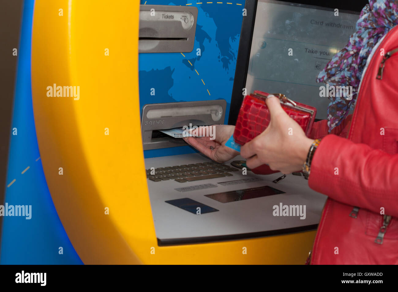 Donna prelevare contanti presso una banca bancomat Foto Stock