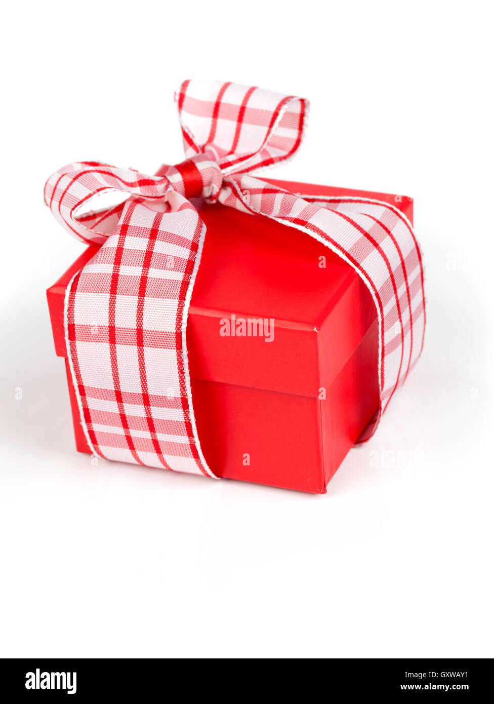 Singola confezione regalo rossa con nastro, su sfondo bianco. Foto Stock