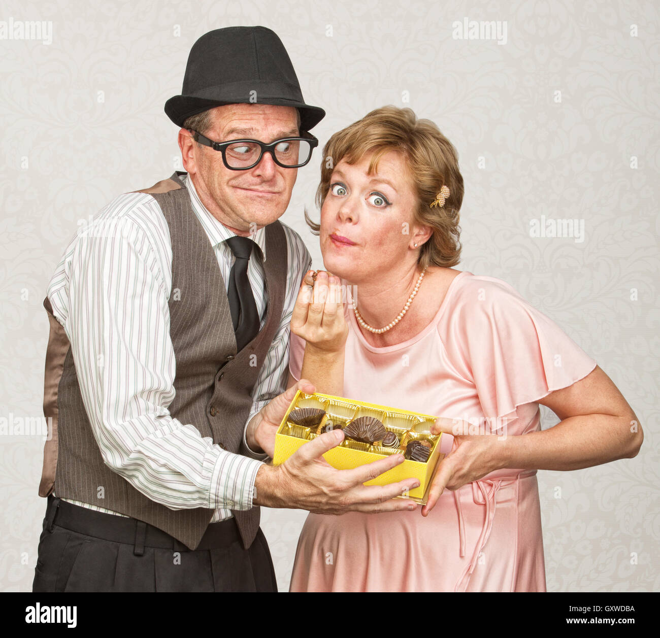 Il marito tenendo le caramelle per donna in stato di gravidanza Foto Stock