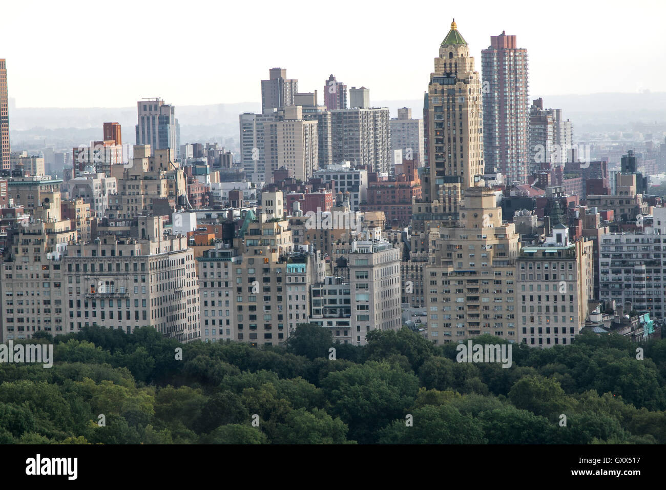 Edifici sul lato est superiore salire sopra gli alberi di Central Park Foto Stock