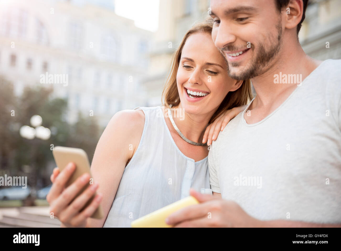 Positivo coppia giovane utilizzando smart phone Foto Stock