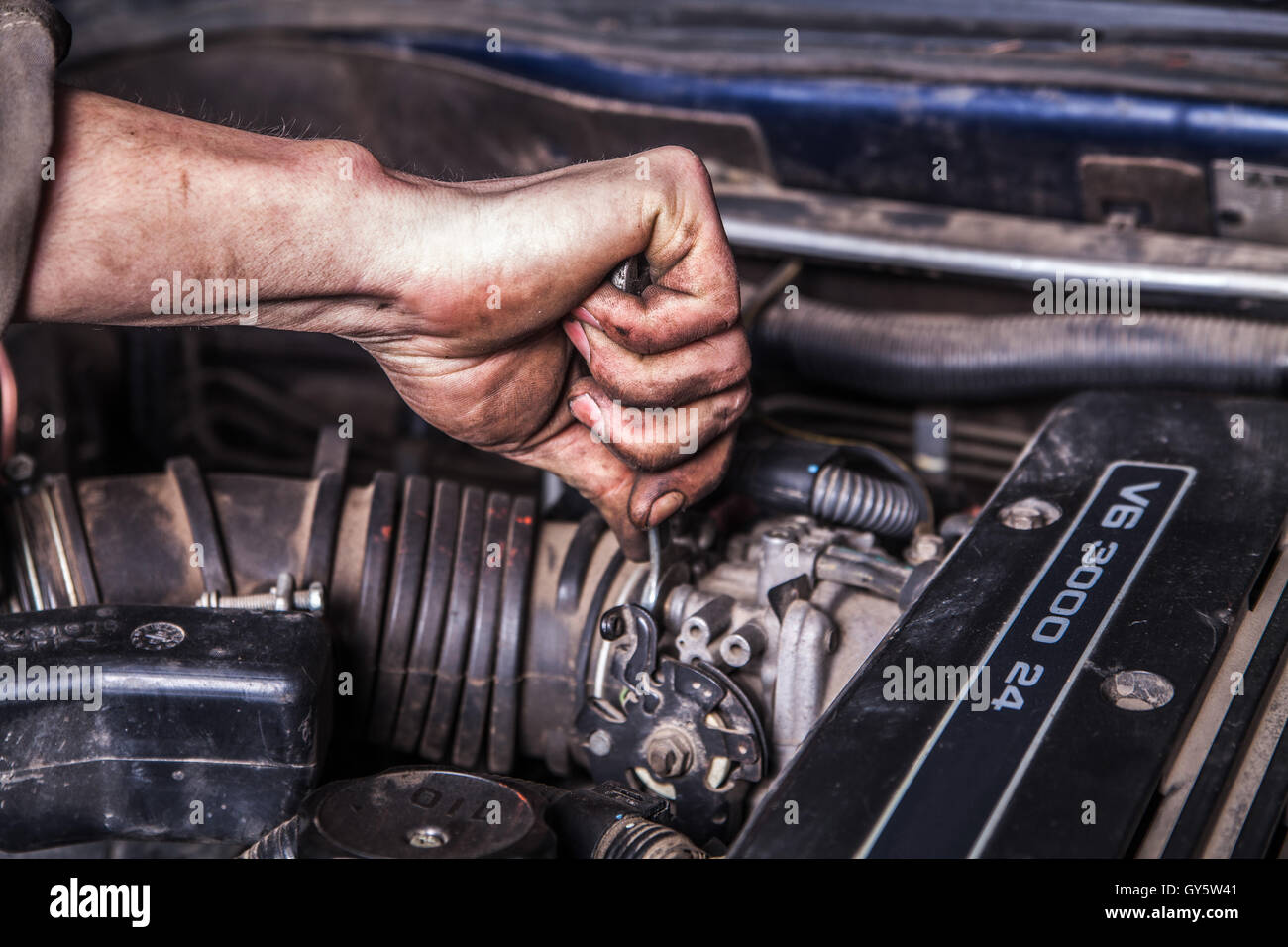 Lavorando gli uomini con le mani sporche e strumenti Foto Stock