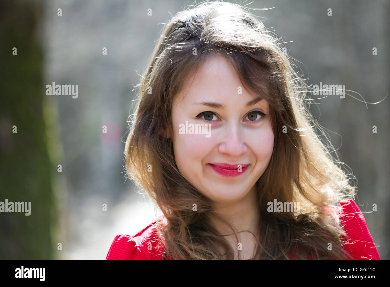 Ritratto di un attraente bella piuttosto carino giovani caucasici sorridendo felice donna (la ragazza, femmina, persona, modello) vestita in rosso Foto Stock