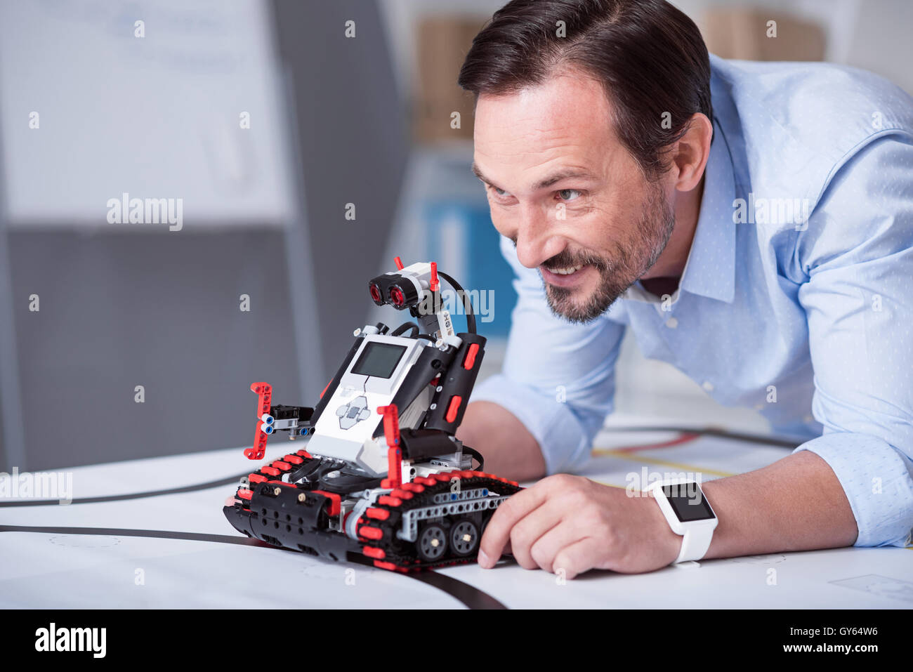 Di mezza età attraente uomo lanciando un robot Foto Stock