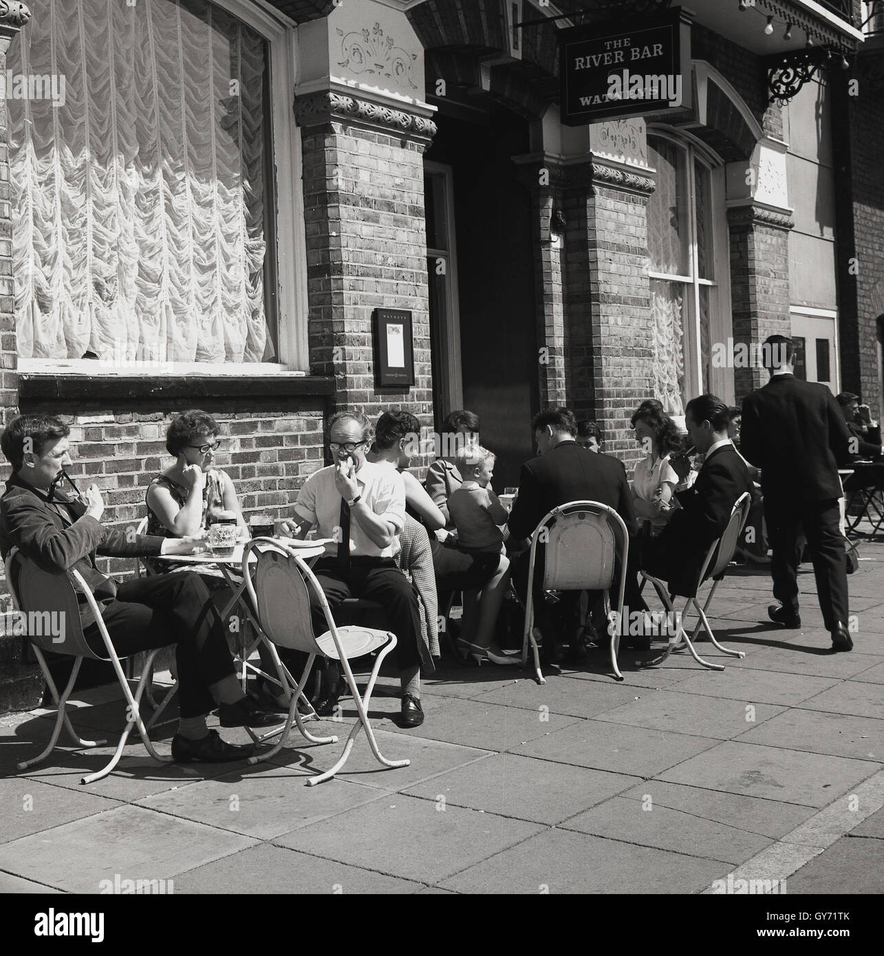 1950s, storico, persone seduti fuori un pub Watneys, The Rutland Arms on the Lower Mall, Londra, W6, un passaggio lastricato accanto al Tamigi, Chiswick, vicino Hammersmith, West London, Inghilterra, REGNO UNITO. Foto Stock