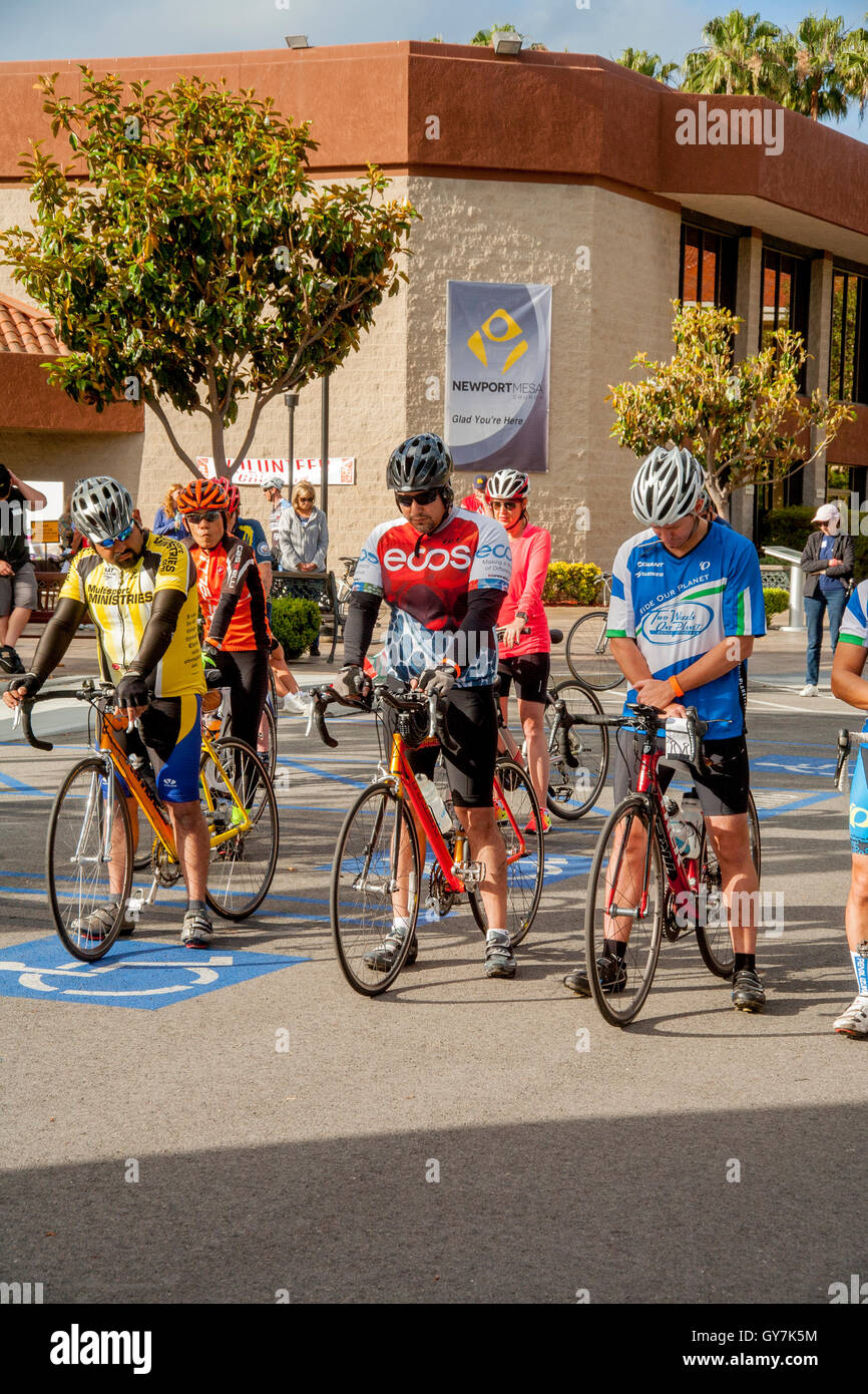 I ciclisti alla linea di partenza di un 55-Mile fund raising carità gara in Costa Mesa, CA. Bow le loro teste in preghiera prima di iniziare la concorrenza. Foto Stock