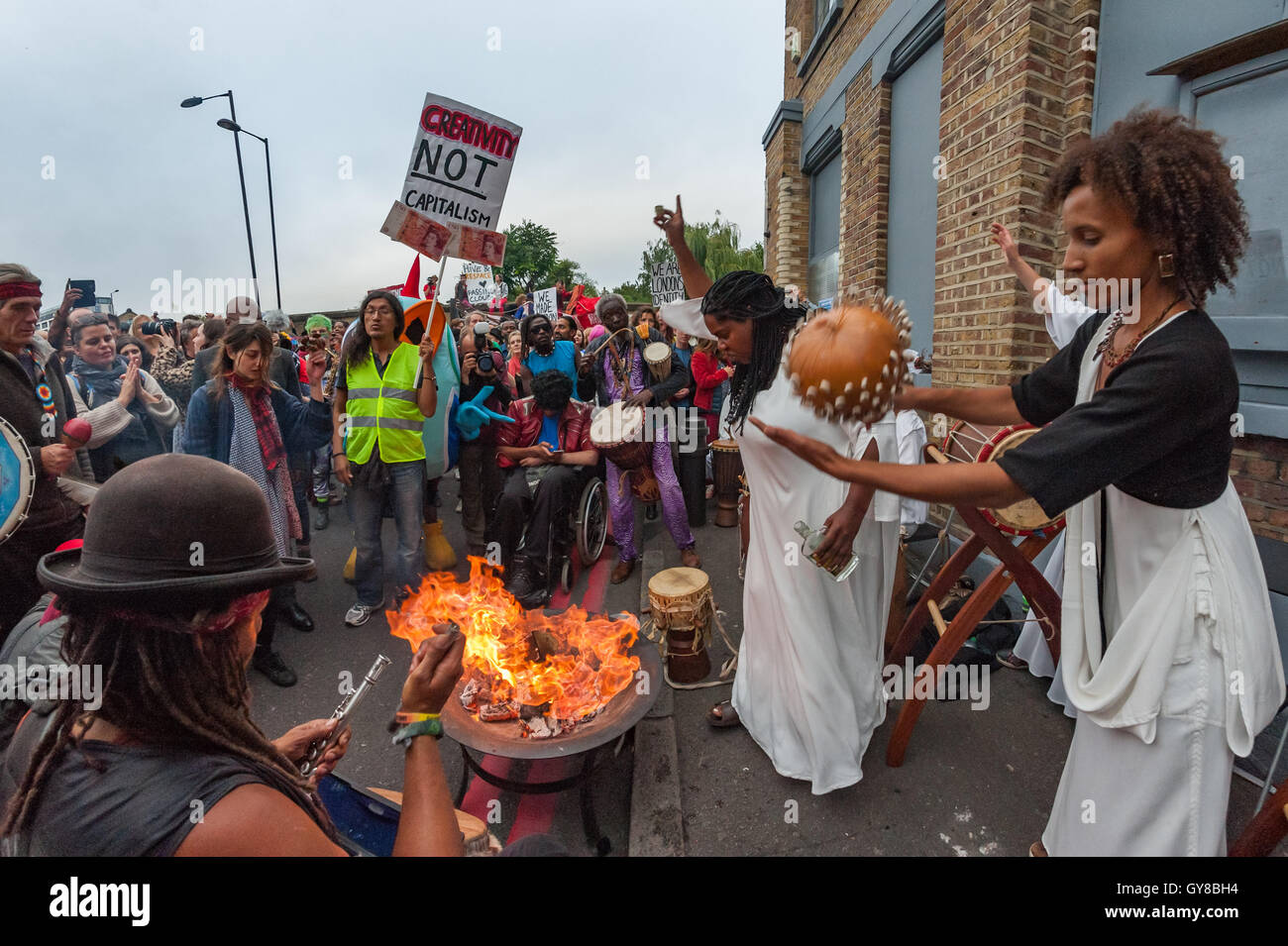 Londra, Regno Unito. 17 Settembre, 2016. Dimostranti arrivano a sostenere il passaggio di nuvole, indipendente London music venue in Haggerston, dove i percussionisti africani e altri ancora sono in attesa di partecipare a una manifestazione di protesta contro la sua chiusura. La folla di circa un migliaio di persone al più presto riempito completamente la strada al di fuori come altri musicisti si sono uniti in e un bianco-placcati donna versata misure di rum bianco su un fuoco di legno che è scoppiata in fiamme. Passare nubi era venduto segretamente a Landhold sviluppi e stata chiusa in quanto ha celebrato dieci anni di esistenza durante il quale ha ospitato oltre 10.000 eventi culturali e musicali. Foto Stock