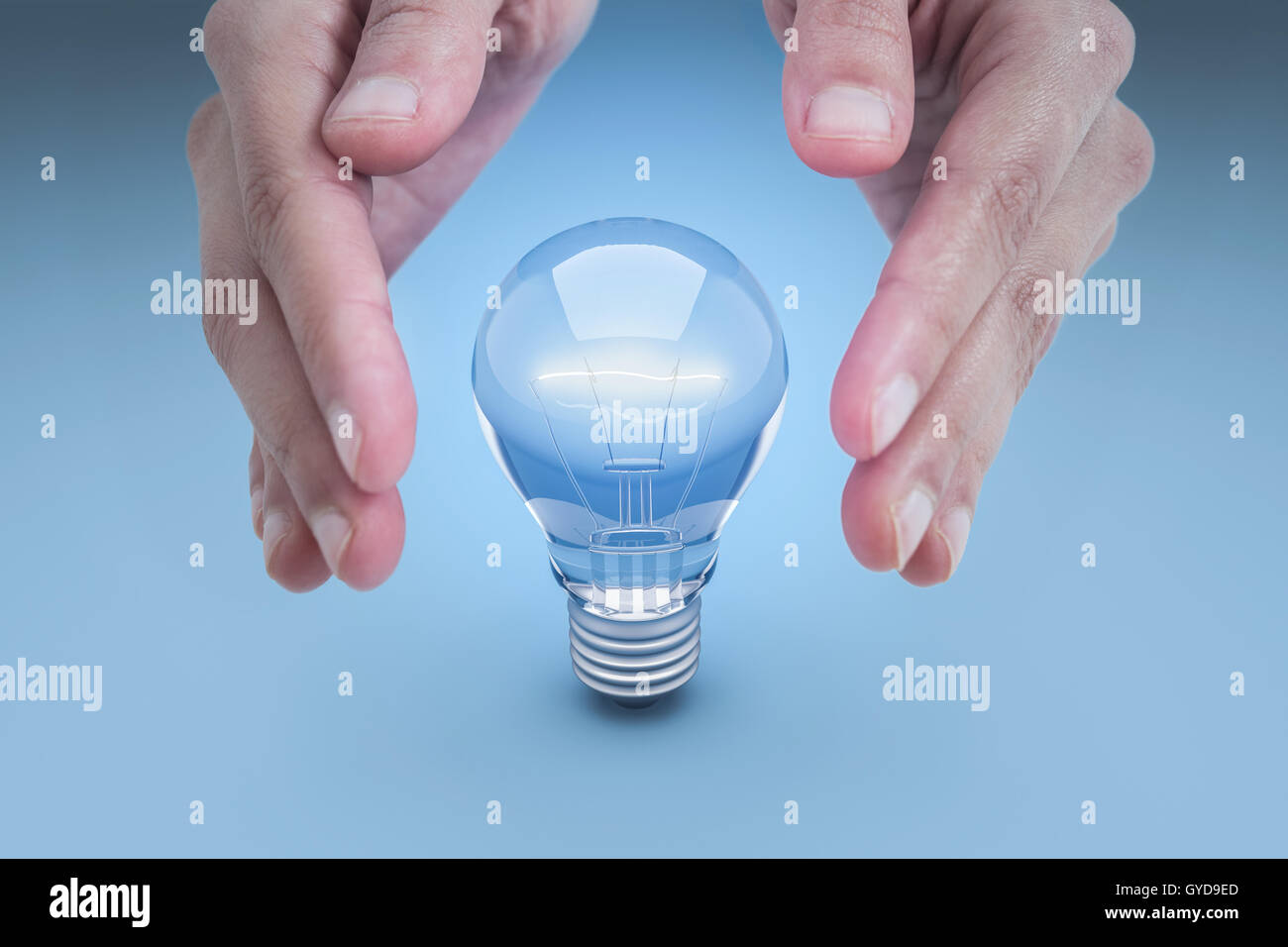 Mano e risparmio energetico lampada su uno sfondo blu Foto Stock
