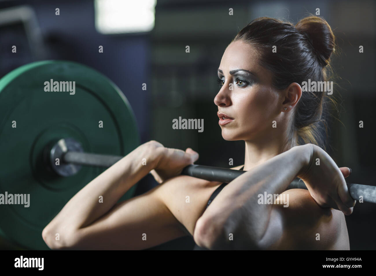 Concetto: Potenza, forza, uno stile di vita sano, sport. Potente attraente donna muscolare CrossFit trainer fare allenamento con barbell Foto Stock