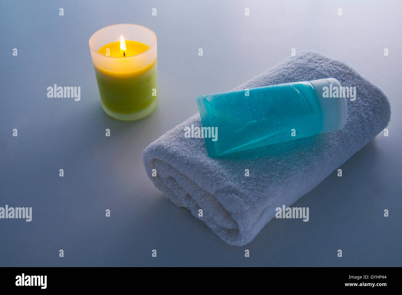Asciugamano, gel e illuminato di candela. Foto Stock