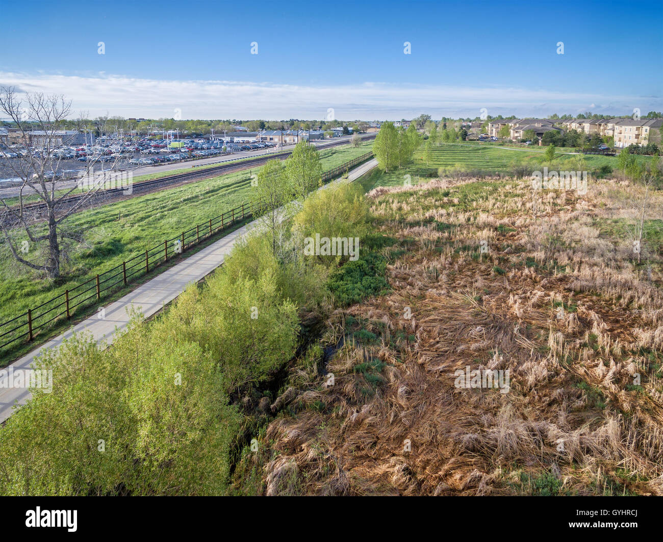 Vista aerea di una pista ciclabile, ferrovia e aree verdi in Fort Collins, Colorado, uno scenario primaverile Foto Stock