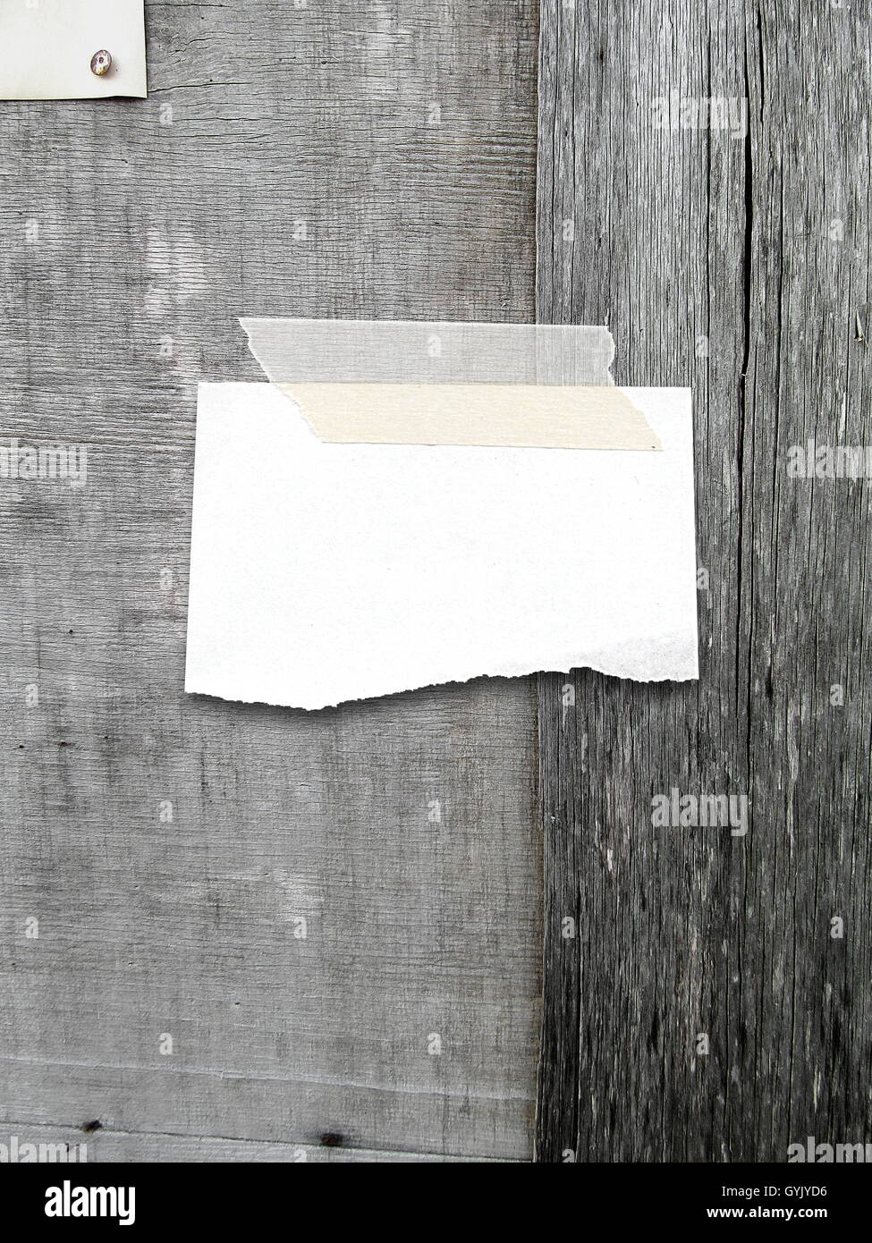 Close-up di uno sbozzato rip pezzo di carta telaio con nastro adesivo sul grigio Sfondo di legno Foto Stock