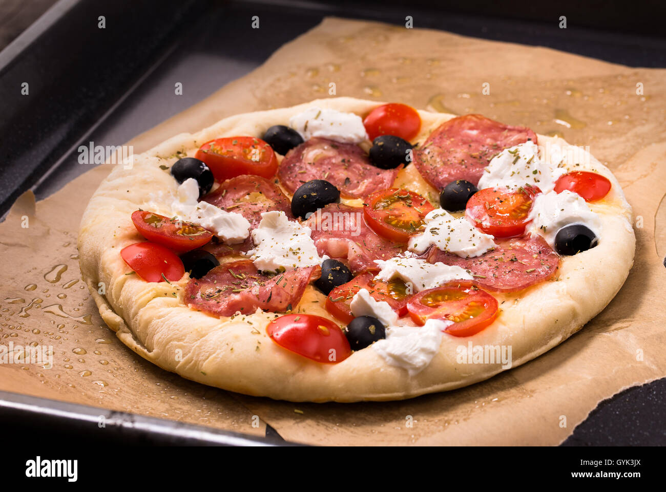 Pizza cruda sul vassoio da forno Foto Stock
