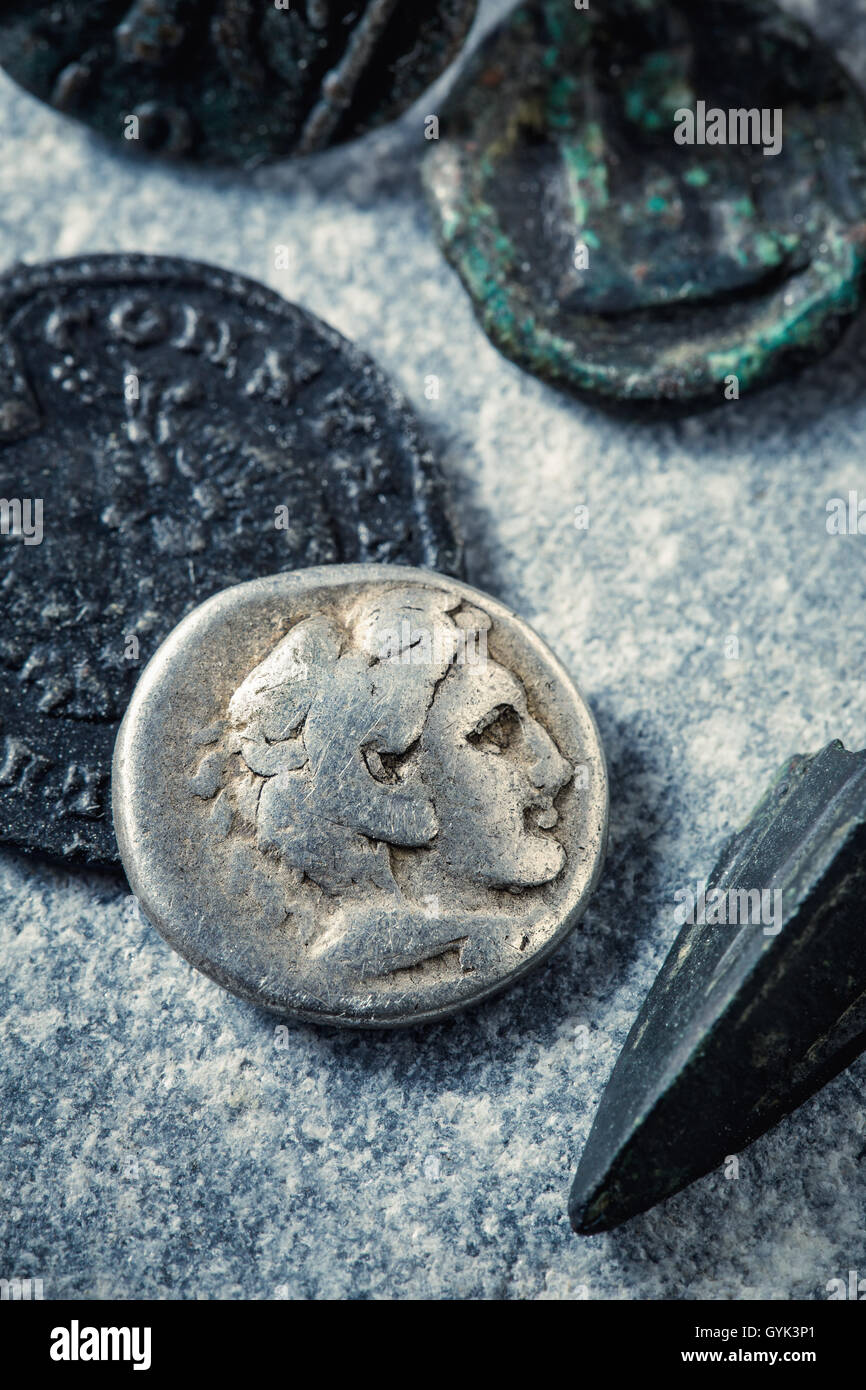 Monete romane e arrowhead Foto Stock