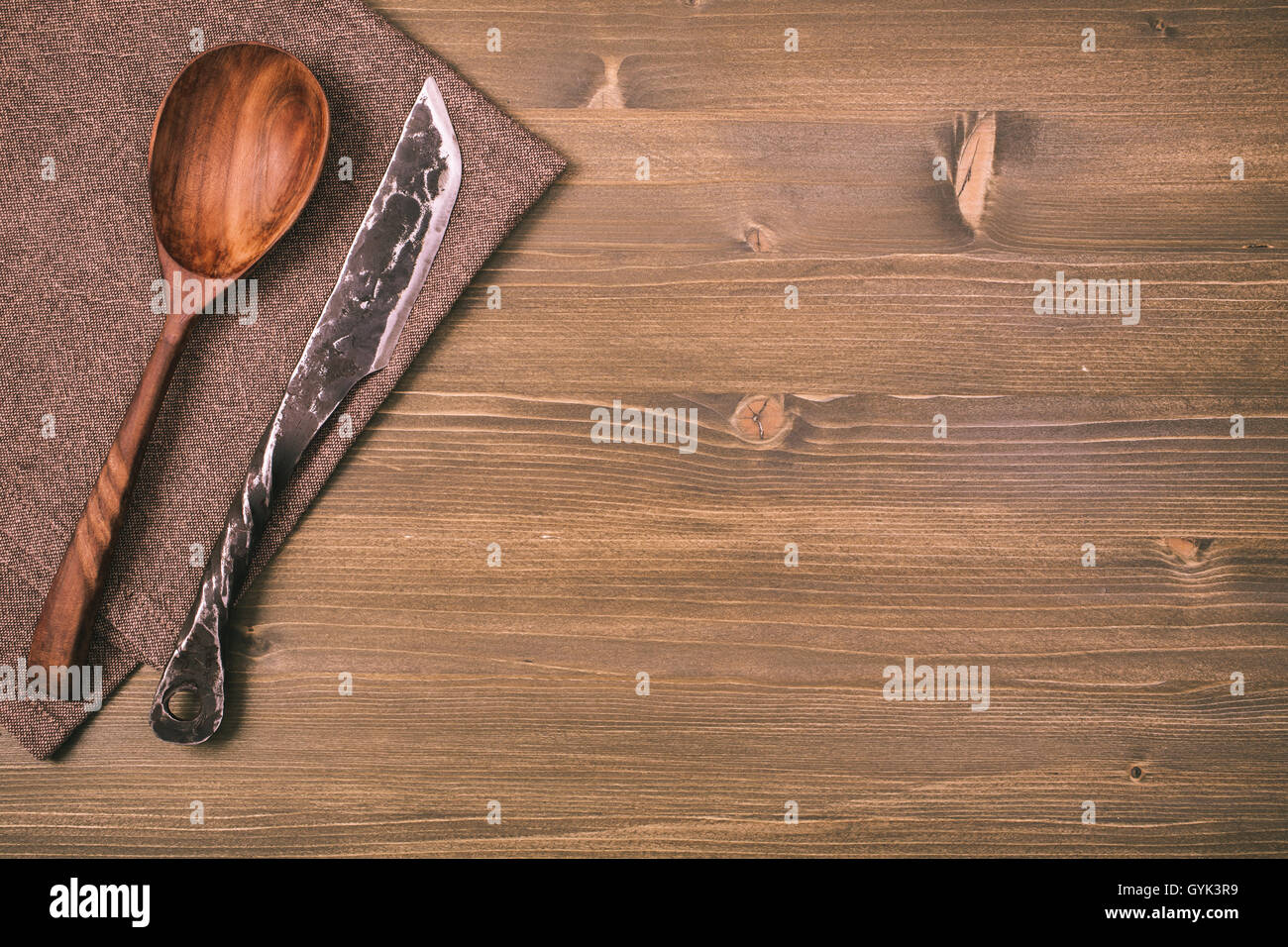 Coltello rustico e cucchiaio su sfondo di legno Foto Stock