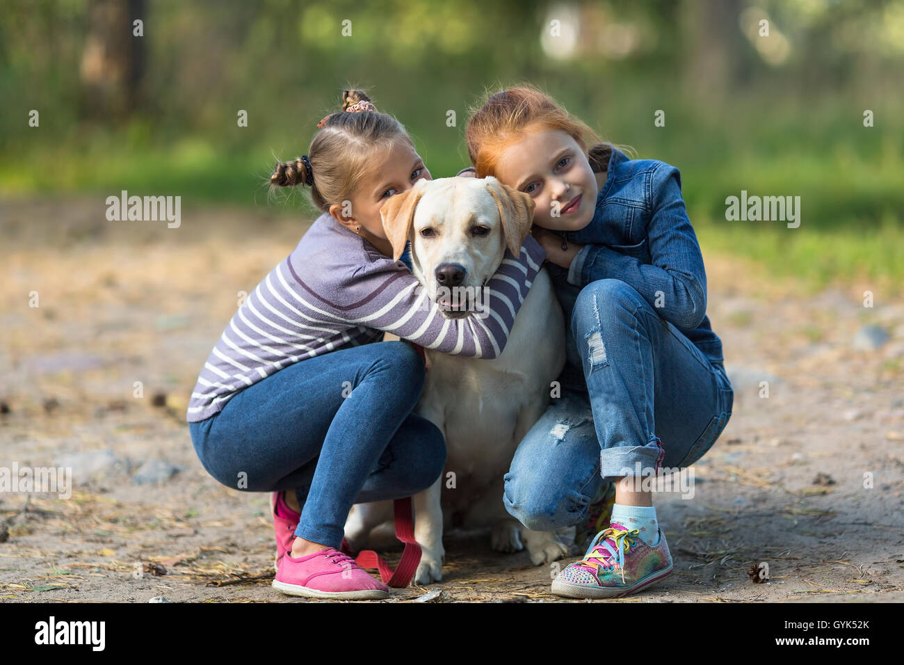 Due bambine con il cane all'esterno. Foto Stock