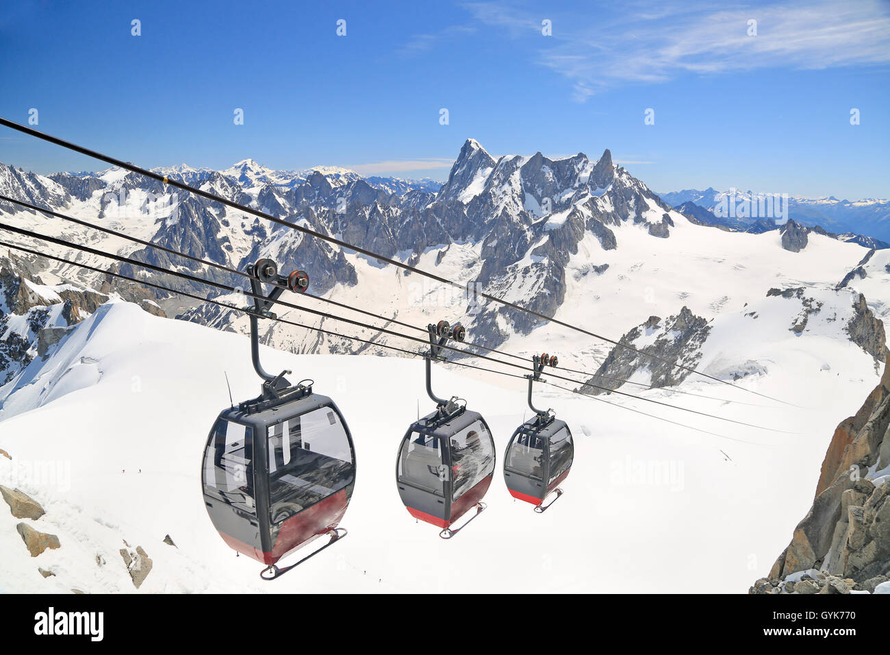 Turisti che si godono il paesaggio maestoso in gondole dalla Punta Helbronner a Aiguille du Midi, Francia Foto Stock
