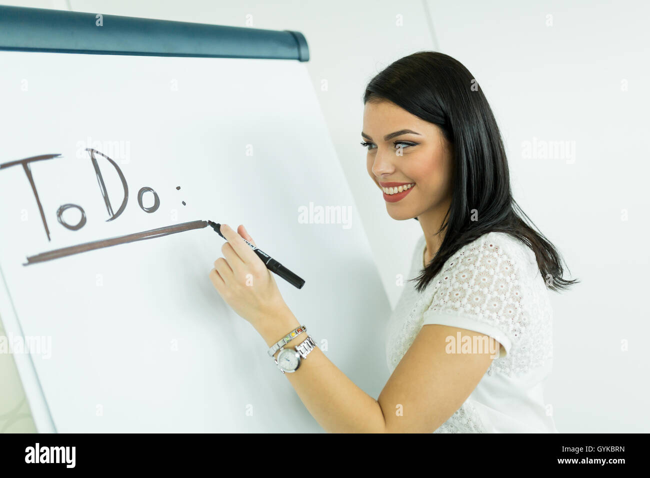 Bella e giovane imprenditrice iscritto todo su un bianco scheda di scrittura Foto Stock