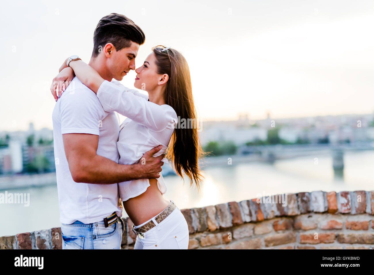 Giovane coppia romantica e abbraccia circa al bacio nel bel tramonto Foto Stock
