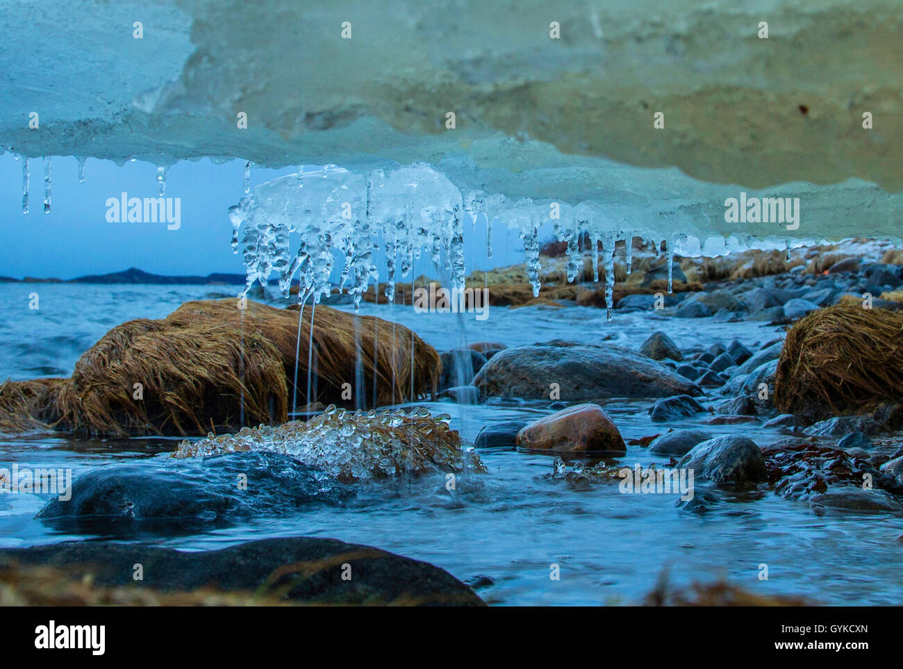 L'acqua di fusione del ghiaccio dalla bocca del fiume scende verso il mare con la bassa marea e forme di perle di ghiaccio, Norvegia, Fylke Troms, Senja Bergsfjord Foto Stock
