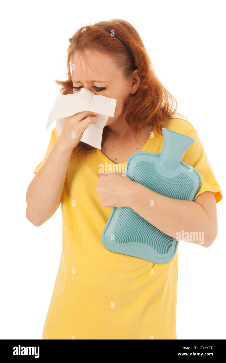 Dai capelli rossi donna soffia il naso con acqua calda-bottiglia Foto Stock
