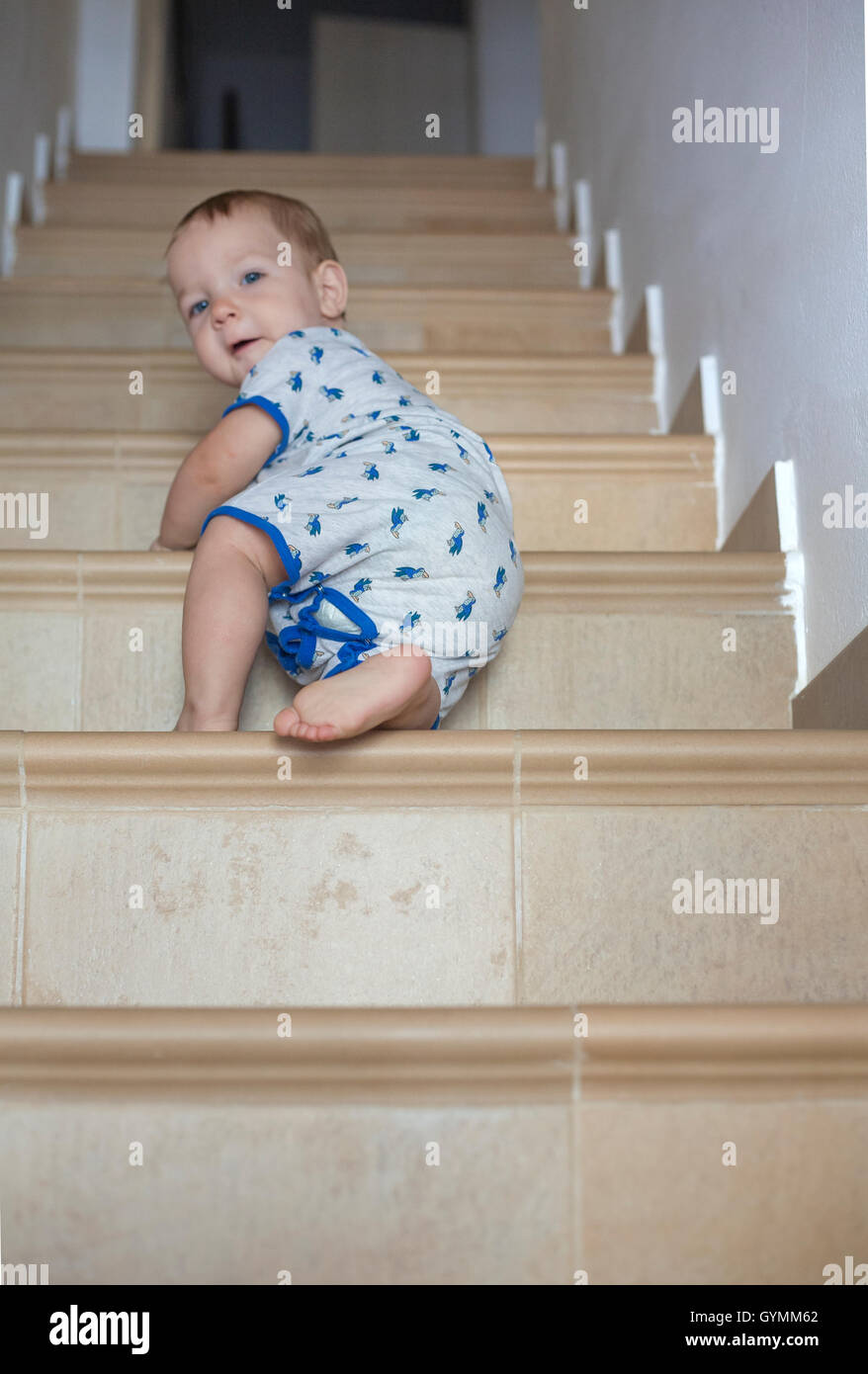 Baby boy strisciando su per le scale. Basso angolo di visione Foto Stock