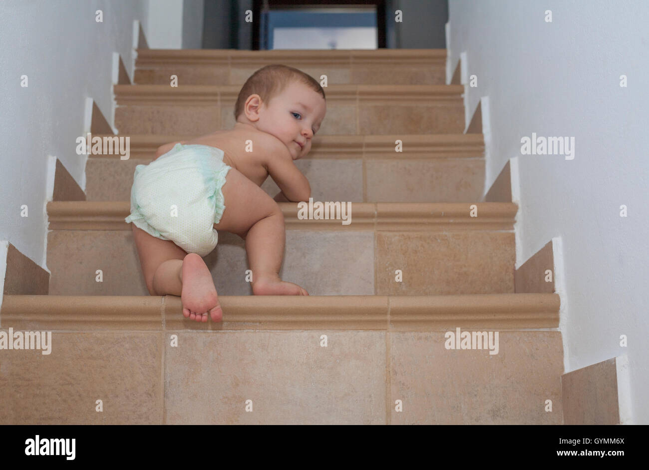 Baby boy strisciando su per le scale. Basso angolo di visione Foto Stock