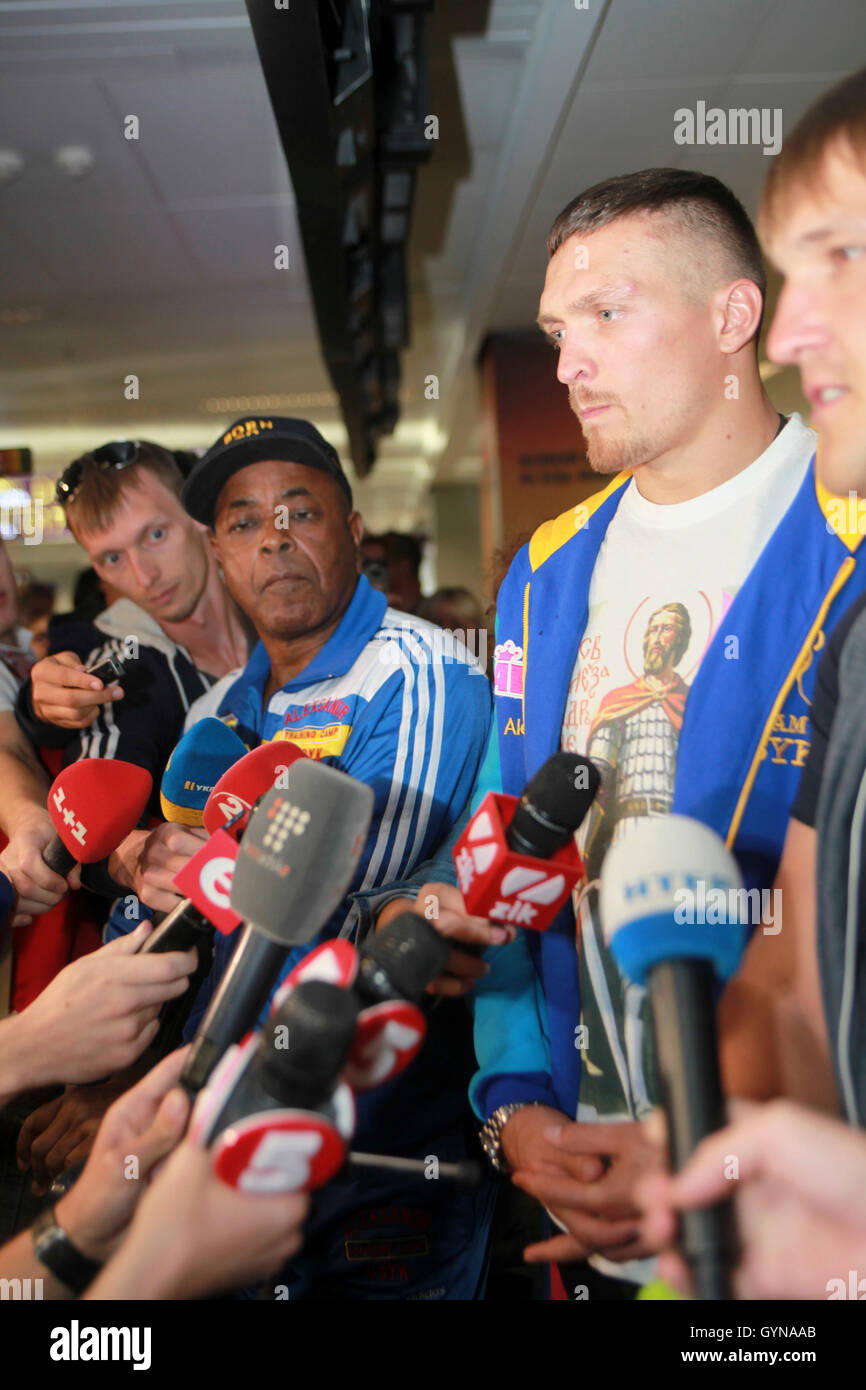 Kiev, Ucraina. 18th Set, 2016. Il 18 settembre 2016 il nuovo campione del mondo Usyk della WBO Cruiserweight dell'Ucraina arrivò a Kiev da Varsavia dopo aver vinto il 17 settembre contro Krzysztof Glowacki a Danzica. Il nativo di Crimea Simpheropol Usyk si è incontrato all'aeroporto Boryspol di Kiev come un eroe nazionale, con il suo allenatore americano James Ali Bashir (a sinistra di Usyk). Usyk ha dichiarato che vorrebbe iniziare l'unificazione dei nastri Cruiserweight dalla lotta contro il campione WBC Briton Tony Bellew. Credit: Dimar PhotoAlamy Live News Foto Stock