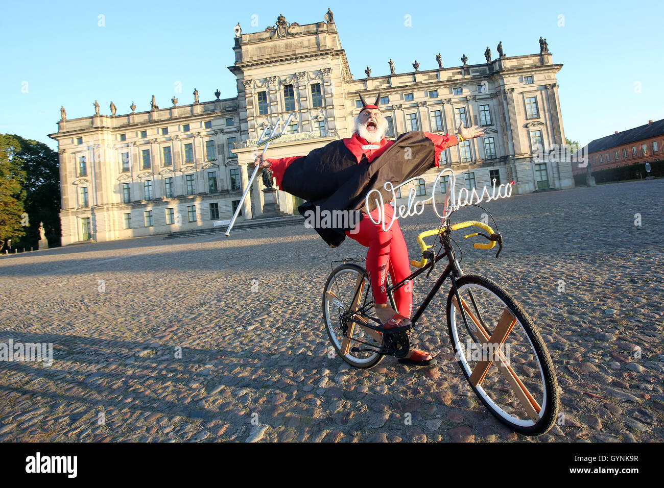 Ludwigslust, Germania. Xviii Sep, 2016. La bike designer Dieter 'Didi' Senft in posa di fronte al castello barocco di Ludwigslust come " El Diablo' prima di partire con il "Velo Classico Germania' con il suo est tedesco biciclette dagli anni sessanta in Ludwigslust, Germania, 18 settembre 2016. Con ruote storiche dagli anni Venti agli anni ottanta e indumenti di corrispondenza circa 300 persone sono iniziata domenica mattina a "velo Classico Germania' in Ludwigslust. Foto: BODO SEGNA/DPA/Alamy Live News Foto Stock