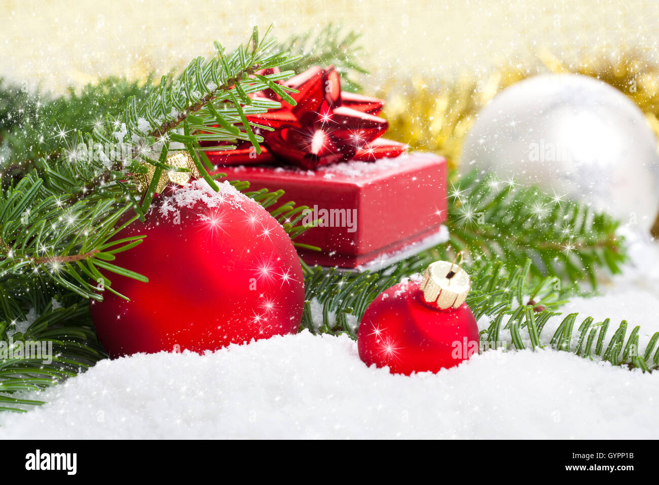 Red palla di Natale con ramo di pino, dono e neve su bianco sno Foto Stock