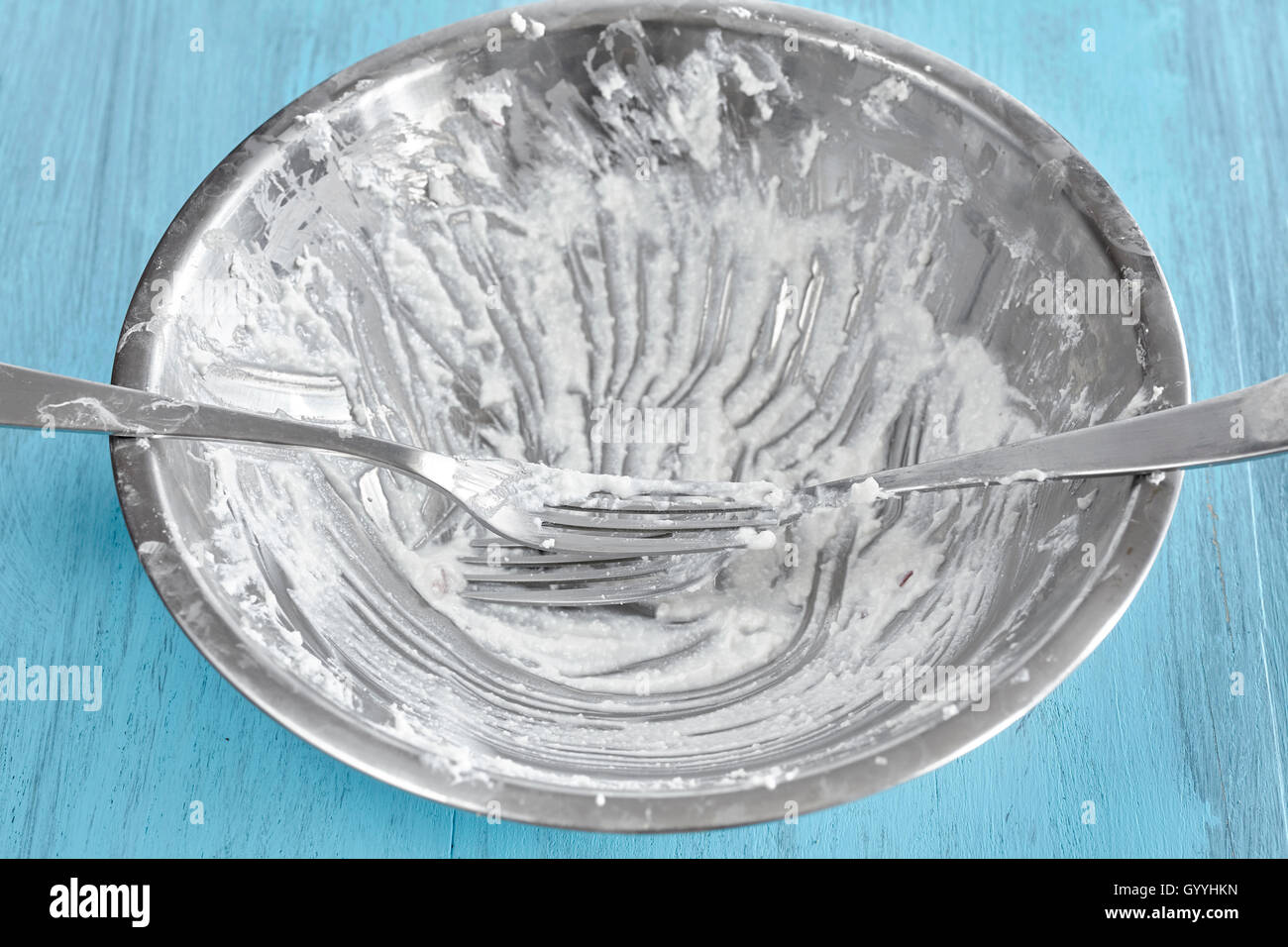 Sporca la coppa d'argento dopo cottage cheese colazione con forche su tavola in legno rustico. Foto Stock
