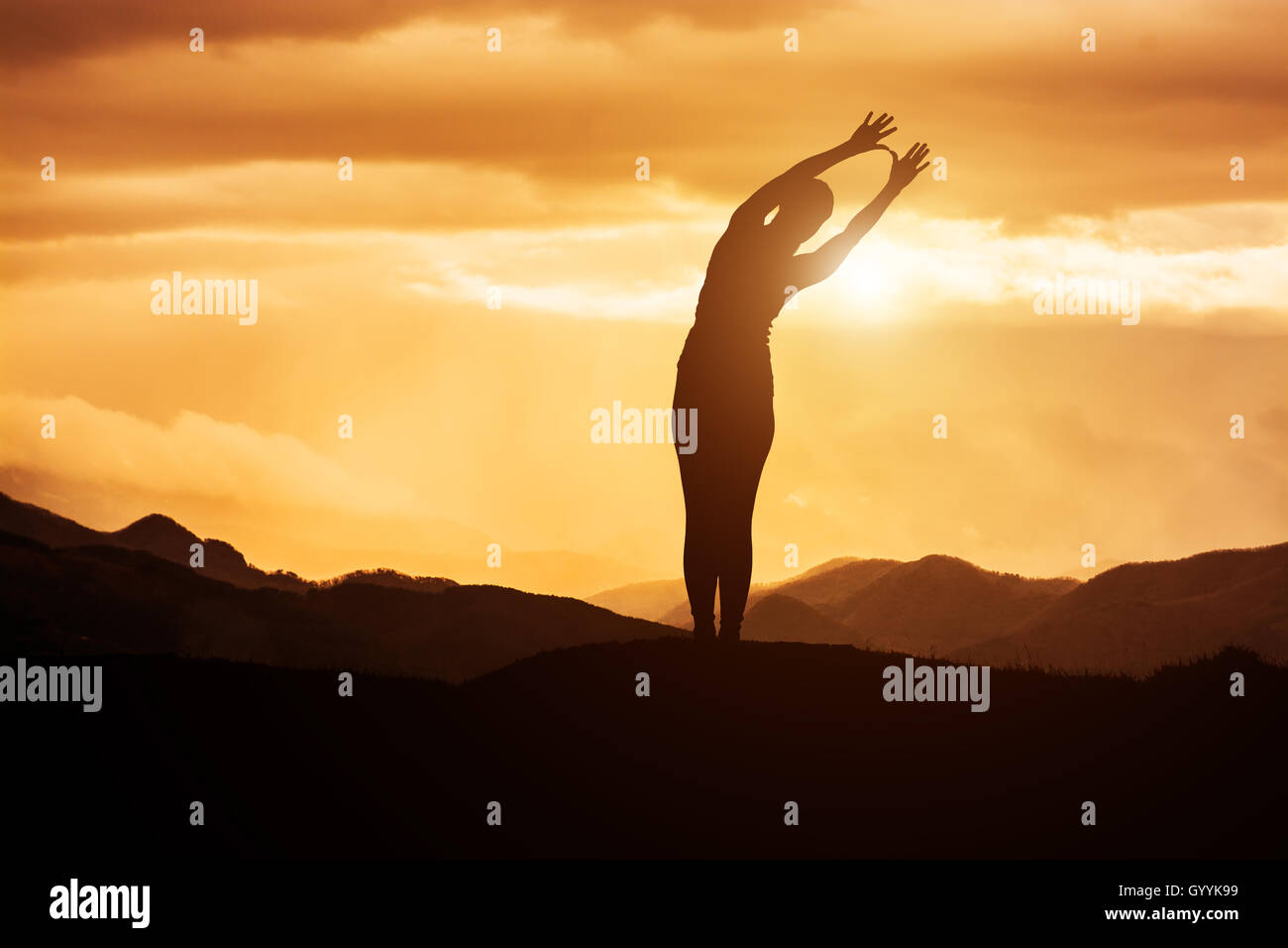 Giovane donna a praticare yoga al tramonto Foto Stock