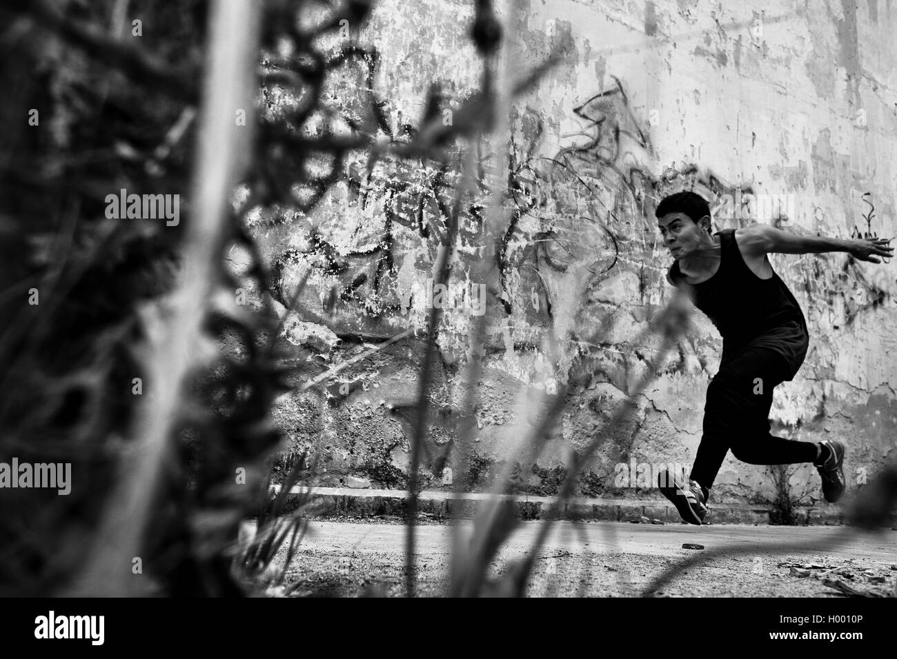 Un colombiano freerunner effettua un salto su un ostacolo durante il parkour sessione di formazione di Bogotá, in Colombia. Foto Stock