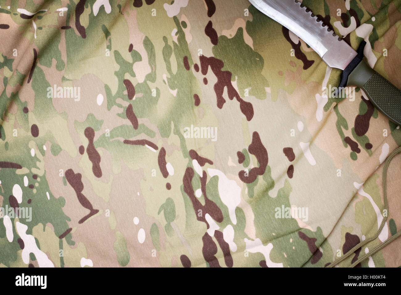 Coltello da combattimento e scarpe militari tessuto camouflage background closeup Foto Stock